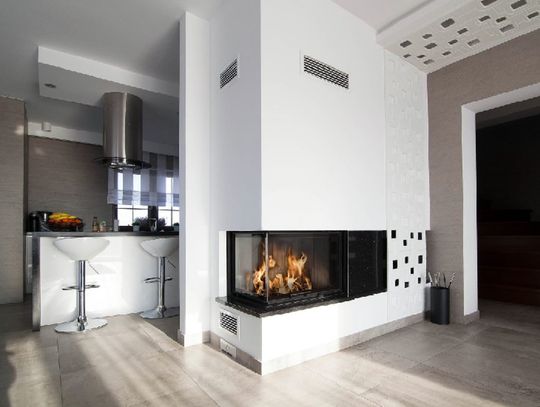 Kominek narożny w jasnym salonie